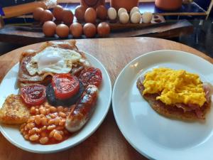 Potter HeighamLittleholme的两盘早餐食品,包括鸡蛋香肠和豆类
