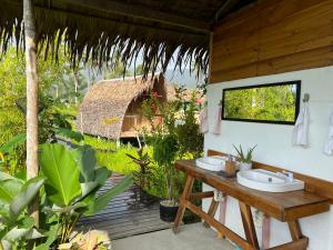 圣维森特Palayan Paradise Huts的一间带水槽和茅草屋顶的浴室