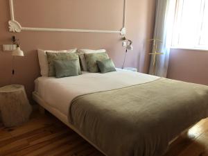 马托西纽什Godinho's House的卧室配有一张带白色床单和枕头的大床。