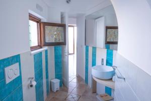 康加德马里尼Emerald's Resort - Filomena的浴室铺有蓝色和白色瓷砖,配有水槽