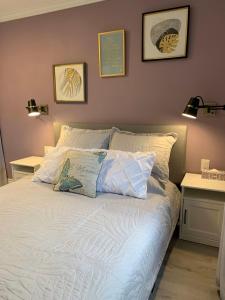 尼亚加拉瀑布Ambiance by the Falls Cozy Suite的卧室内的一张带白色床单和枕头的床