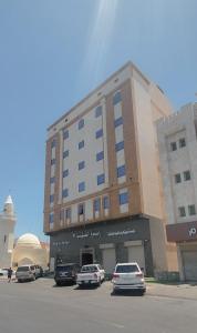 麦地那فندق ربوة الصفوة 8 - Rabwah Al Safwa Hotel 8的停车场内有车辆的建筑物