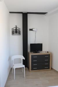 UserasCa ma mare的一间带椅子、电视和橱柜的房间