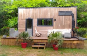 Gaillan-en-MédocTiny house chez Caroline的一座小房子,坐在种有植物的甲板上