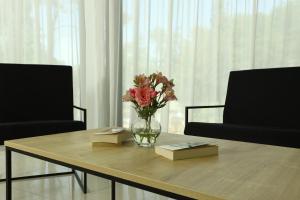 谢赫维蒂利Graphica Black Sea的花瓶坐在桌子上,摆放着两把椅子