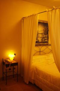 Porto Levante帕拉迪罗酒店的一间卧室配有一张床和一张带台灯的桌子