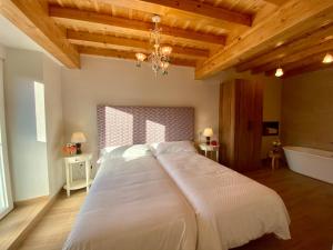 SuanoCasa Rural El Trineo de Campoo - Alto Campoo的卧室设有一张白色大床,拥有木制天花板