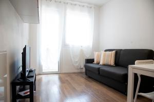 帕多瓦Appartamenti Scrovegni的客厅配有黑色沙发和电视