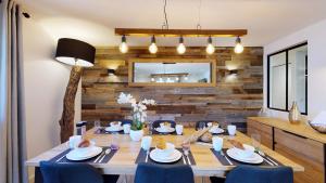 尚帕尼恩瓦努瓦茲Élégant et Moderne avec Vue Montagne au Coeur de Paradiski - Garage - 8pers - 90m2 - Sabaudinha的一间带木桌和蓝色椅子的用餐室