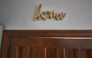 隆达布达郎奇公寓的门上的一个标牌,上面写着“回家”字,墙上写着