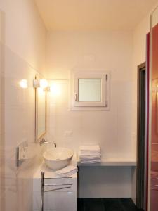 毕博纳的码头卡萨帝卡恰公寓的白色的浴室设有水槽和镜子