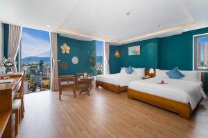 岘港岘港玛丽兰德酒店的酒店客房设有两张床和一张桌子。