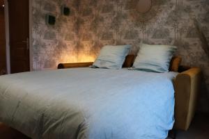 沙勒维尔-梅济耶尔Le Bohème的卧室内的一张带蓝色床单和枕头的床