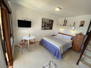 贝纳尔马德纳Benalmadena ALOHA PLAYA SEA VIEW LOFT的一间卧室配有一张床、一张桌子和一台电视。