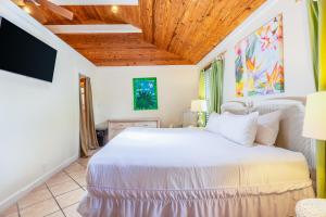 基韦斯特Key Lime Calypso的卧室设有白色的床和木制天花板。
