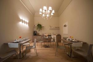巴列塔Antica Dimora Luxury Rooms的一间带桌椅和吊灯的用餐室