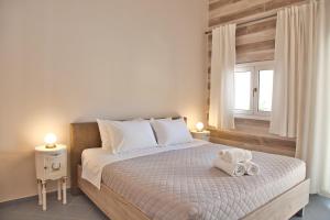斯卡拉Porfyra Suite & Spa 1的一间卧室配有一张床,上面有两条毛巾