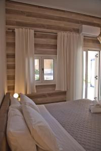斯卡拉Porfyra Suite & Spa 1的卧室配有一张带白色床单和窗户的大床。