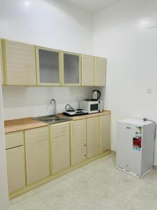 艾卜哈رافا للشقق السكنية的厨房配有木制橱柜和白色冰箱。