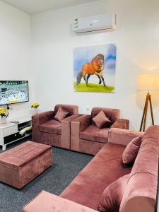 艾卜哈رافا للشقق السكنية的客厅配有2张棕色沙发和电视
