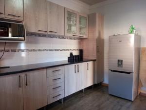 威廉王城G Guest House的厨房配有木制橱柜和不锈钢冰箱。