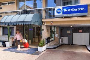 芒通Best Western Hotel Mediterranee Menton的走在最好的西商店前面的人