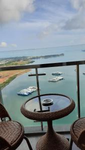 巴淡岛中心Vanilla One Residence Apartment Batam的阳台上的桌椅,船上有船只