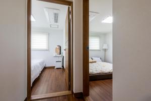 西归浦市海威池私人度假屋的卧室和卧室的镜子