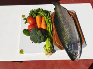 奥科苏尤Amantani Pachatata Lodge的上面有蔬菜和鱼的白盘