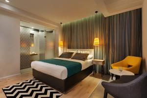 特拉维夫普利马城市酒店的一间卧室配有一张床、一张桌子和一把椅子
