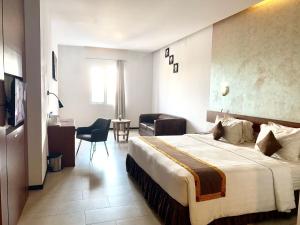 明古鲁省明古鲁艾科斯塔酒店的酒店客房带一张大床和一把椅子