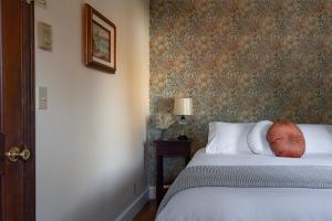 帕克伍德Historic Hotel Packwood的一间卧室配有一张带花卉壁纸的床