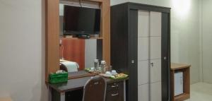 TatakirenEdhotel Kusuma Atambua Mitra RedDoorz的客房设有一张带电视和镜子的书桌。