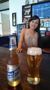 八丹拜Zen inn的坐在酒吧里喝一杯啤酒的女人