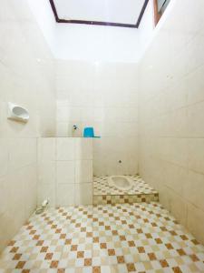 泗水Homey Guesthouse Kertajaya (Syariah)的铺有瓷砖地板,设有带卫生间的浴室