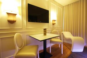 Pedroso丝绸汽车旅馆的酒店客房配有桌椅和电视。