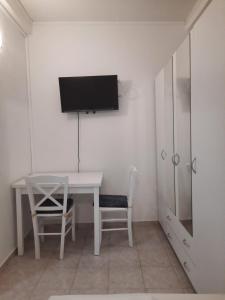 洛帕Apartmani Ana-Lora的客房设有书桌和墙上的电视
