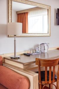 帕兰加信息酒店的一张带镜子的桌子和一张带椅子的桌子