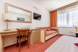 帕兰加信息酒店的酒店客房配有书桌和沙发。