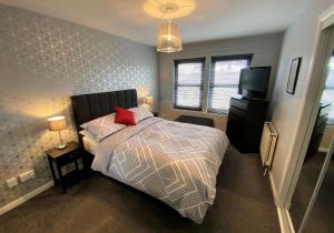 福尔柯克NEW Super 2 Bedroom Flat in Falkirk的一间卧室配有一张床和一台电视