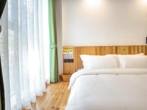 黄山风景区黄山云坊客舍（黄山风景区换乘中心店）的一间卧室设有两张床和窗户。