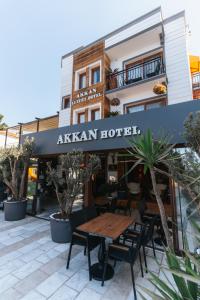 博德鲁姆Akkan Hotel的大楼前设有木桌的餐厅