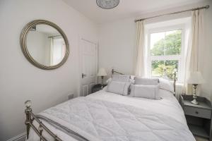 玛丽波特Billy's Cottage的白色卧室配有床和镜子
