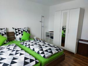 巴特贝林根Haus Kramer的一间卧室配有一张绿色的黑色和白色的床。