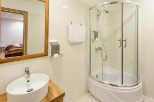 尤尔马拉日落酒店的一间带玻璃淋浴和水槽的浴室