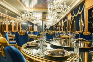 贝尔格莱德Prezident Palace Belgrade - Adults Only的用餐室配有桌椅和吊灯。