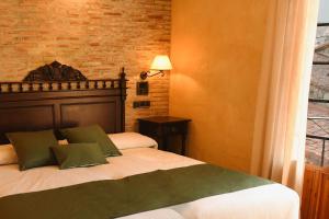 比努埃萨Hotel Rural Villa de Vinuesa的一间卧室设有一张床和砖墙