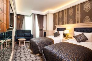 伊斯坦布尔The Conforium Hotel İstanbul的酒店客房,配有两张床和椅子
