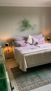 林茨Jules&Jim Gästehaus的一间卧室配有一张带紫色枕头的大床