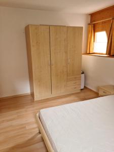 圣玛利亚瓦尔姆斯塔尔Lumpaz的一间卧室配有一张床和木制橱柜